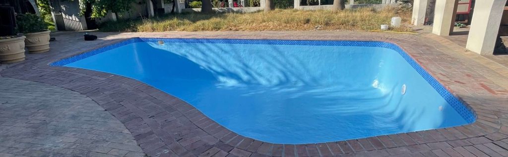 “Fully restored smooth fibreglass swimming pool in Piketberg Western Cape with clean blue water and modern sealed finish”