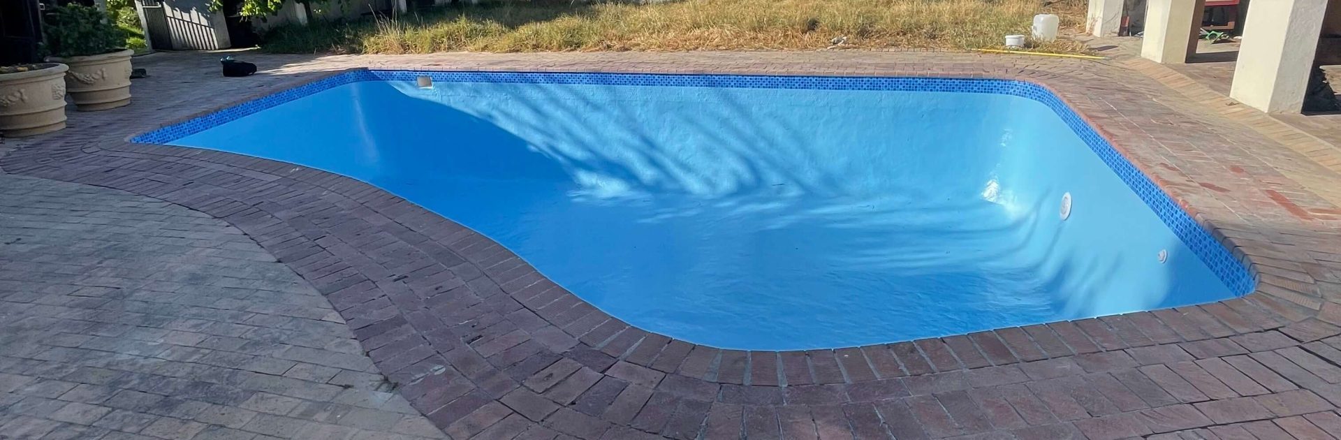 Old marbelite swimming pool upgraded with fibreglass lining showing smooth blue modern finish in Cape Town