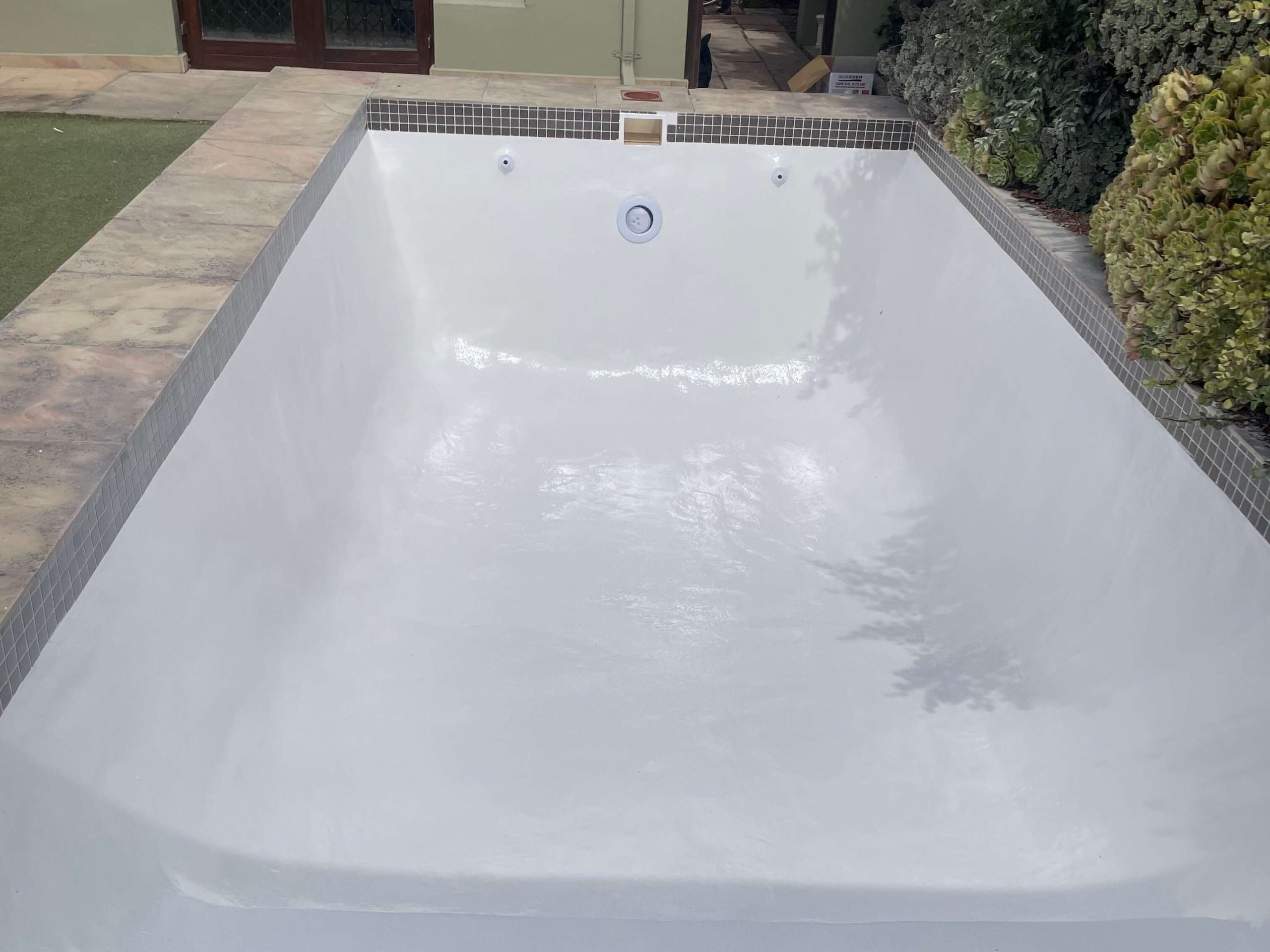 Newly fibreglass lined and painted white swimming pool in Cape Town with a smooth glossy finish after professional pool resurfacing
