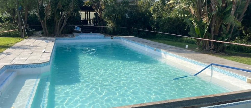Marbelite swimming pool after resurfacing with black algae removed showing clean smooth blue surface in Langebaan