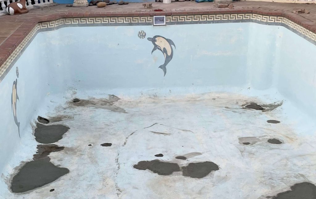 Cracked stained swimming pool surface needing fibreglass relining in Langebaan