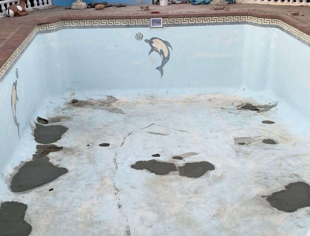 Cracked stained swimming pool surface needing fibreglass relining in Grabouw