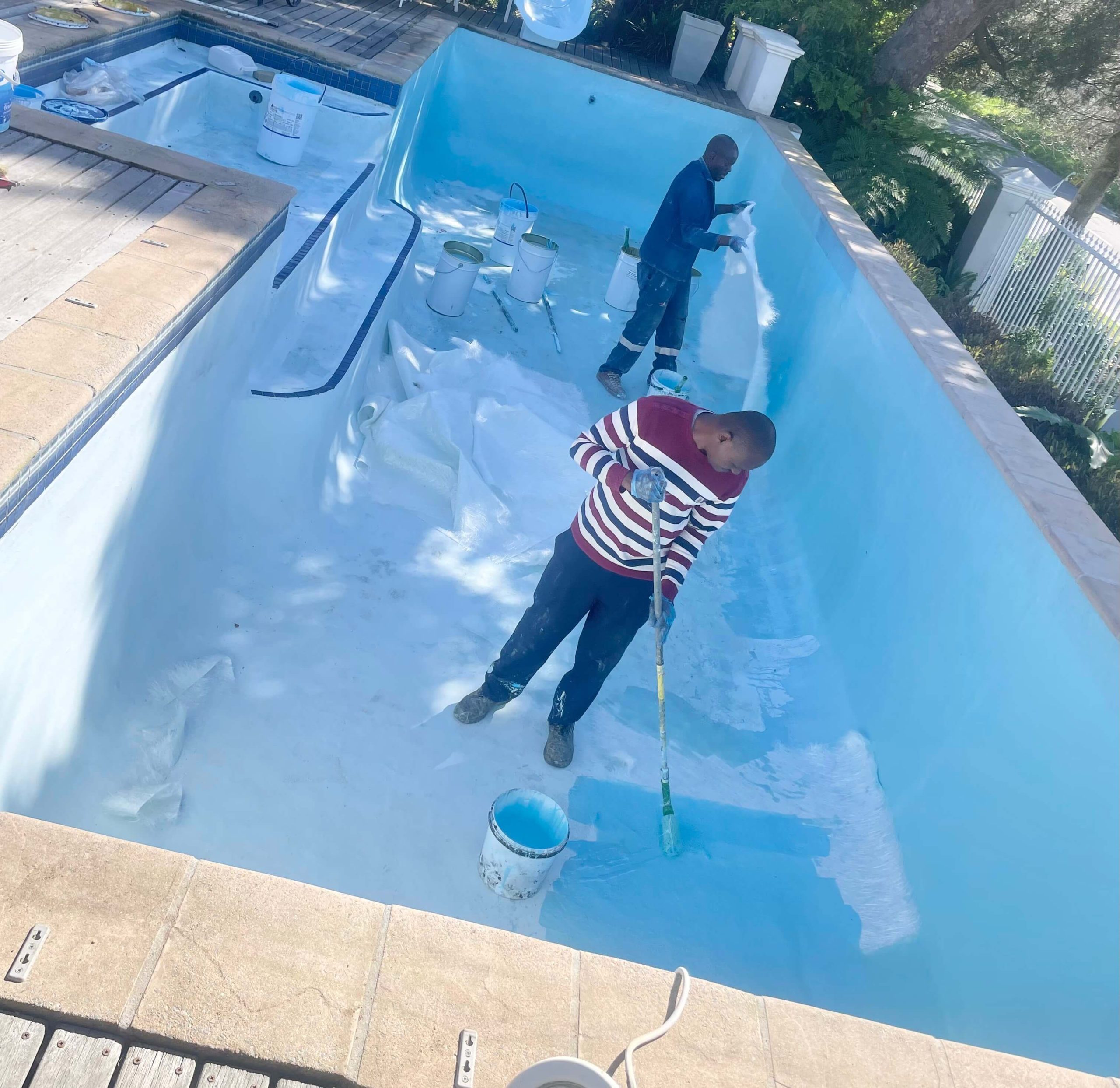 Pool technicians installing fibreglass lining inside a swimming pool during a professional pool renovation project in Cape Town, Western Cape South Africa.