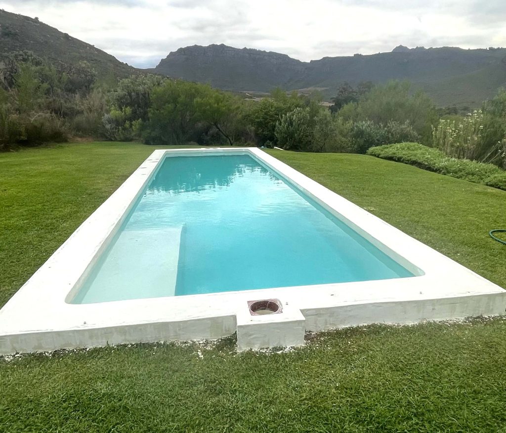 Freshly resurfaced white marbelite swimming pool in Durbanville filled with clear water showcasing smooth modern renovation finish