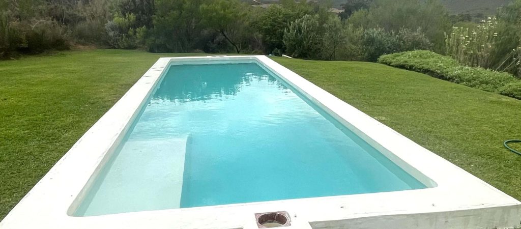Freshly resurfaced white marbelite swimming pool in Melkbostrand filled with clear water showcasing smooth modern renovation finish