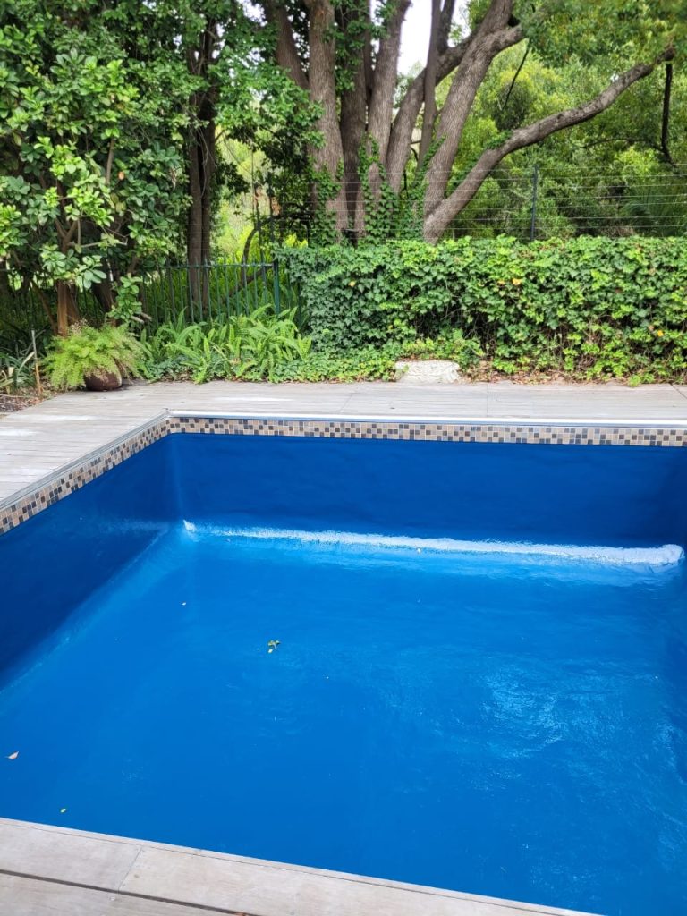 Fibreglass relined and freshly painted blue swimming pool in Malmesbury with smooth modern finish, crystal clear water and renovated pool surface by Pools Reno Western Cape