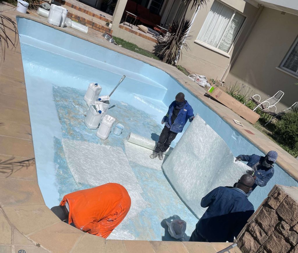 Fibreglass matting installation during swimming pool relining process in Yzerfontein