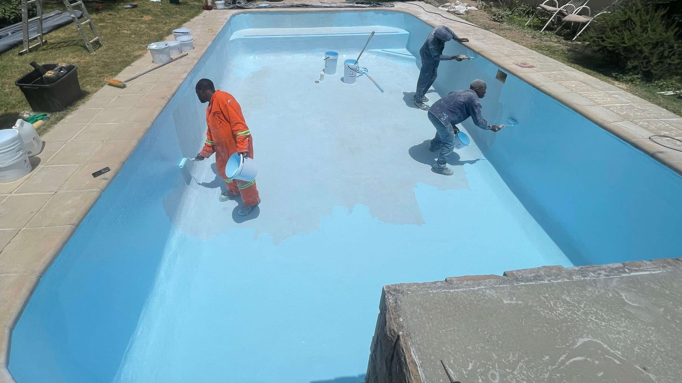 Blue fibreglass flow coat finish being applied to renovated swimming pool in Yzerfontein