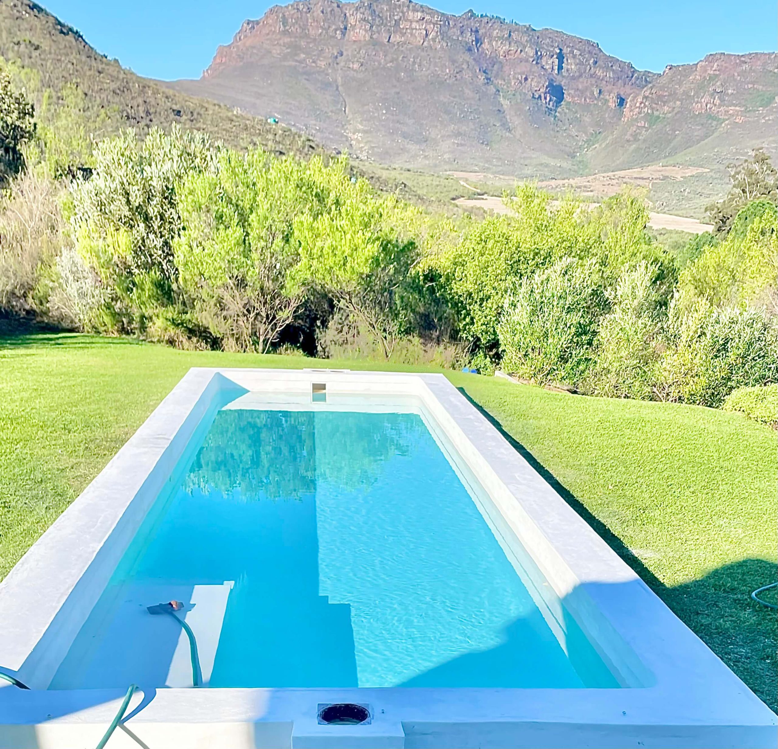Newly renovated swimming pool in Philadelphia Western Cape with modern fibreglass finish, crystal clear water, upgraded paving and stylish outdoor entertainment area by Pools Reno