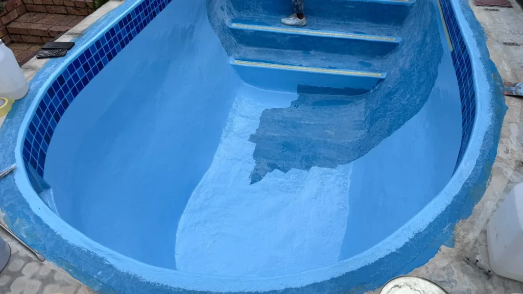 Final pool coat partly applied on the floor and steps of the relined pool