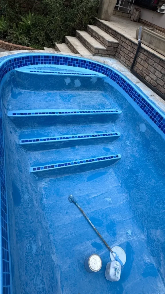 Finished pool steps with dark blue mosaic tiles along each step edge