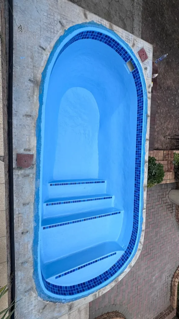 Overhead view of the finished relined pool with its mosaic waterline and step tiles