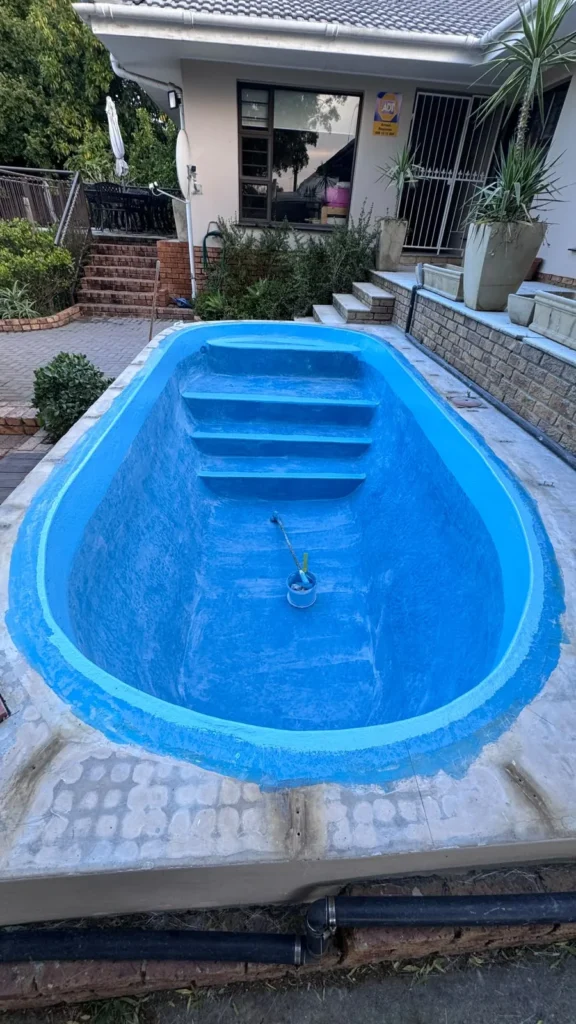 Finished relined pool in front of the house, before the new copings were laid