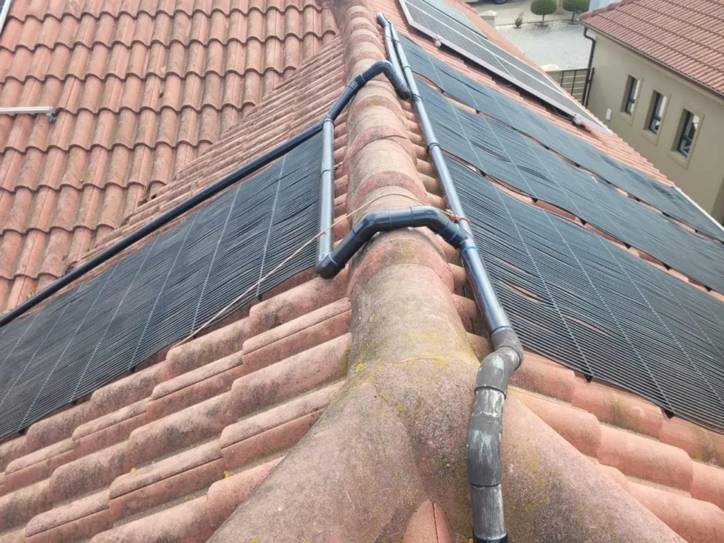 Close view of the solar pool heating pipework crossing the roof ridge