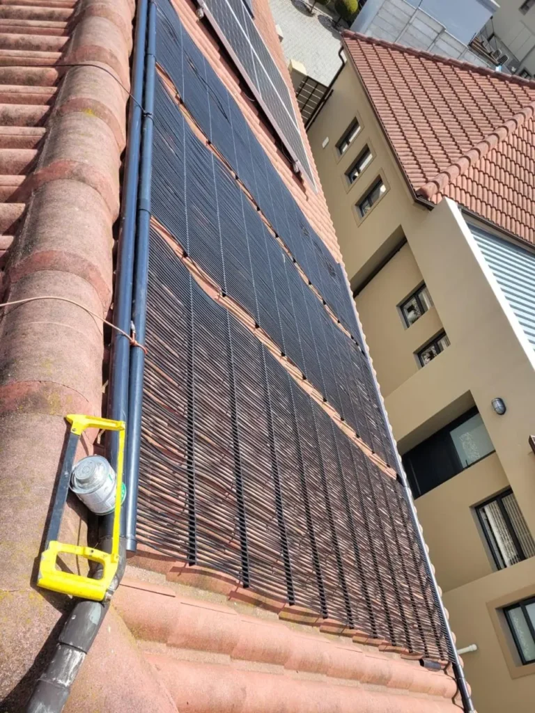 Solar pool heating panels along the edge of the roof with the feed pipe